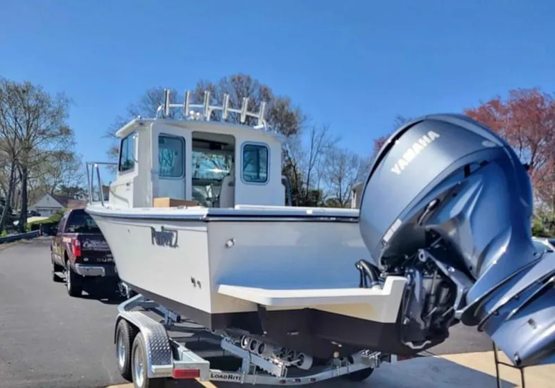 Slide: The Image of 2022 Parker 2320 SL Sport Cabin boat on trailer with Yamaha outboard motor. - 2