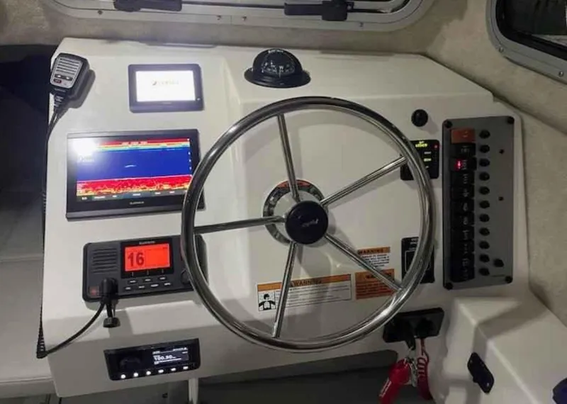 Slide: The Image of 2022 Parker 2320 SL Sport Cabin dashboard with steering wheel and navigation instruments. - 6