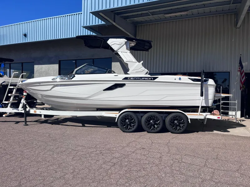 Slide: The Image of 2025 Centurion Ri245 boat on trailer outside a building. - 1