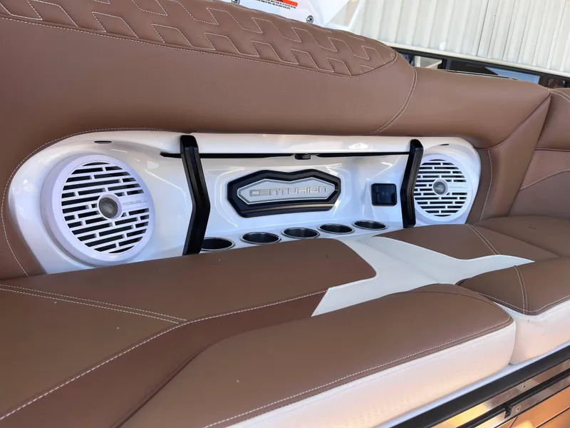 Slide: The Image of Centurion Ri245 2025 boat interior with brown leather seats and built-in speakers. - 13
