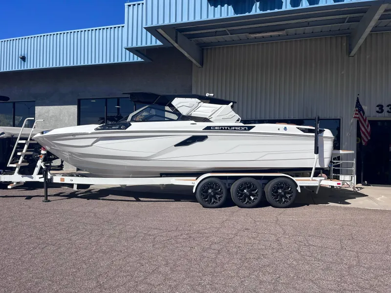 Slide: The Image of 2025 Centurion Ri245 boat on trailer outside a building. - 2