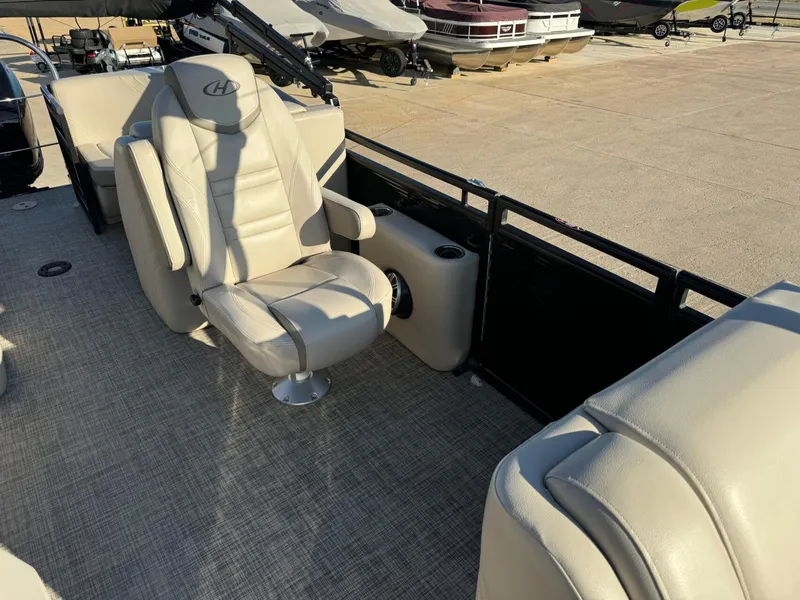 Slide: The Image of 2018 Harris Solstice 240 boat interior with beige captain's chair and carpeted floor. - 13