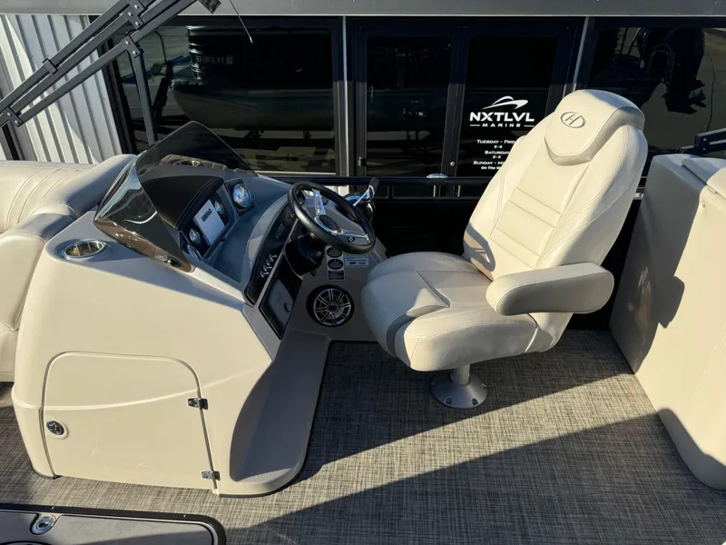 Slide: The Image of Captain's seat and helm of 2018 Harris Solstice 240 pontoon boat, featuring modern controls. - 14