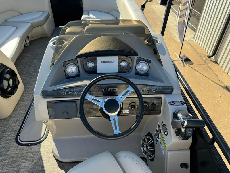 Slide: The Image of 2018 Harris Solstice 240 boat dashboard with steering wheel and Simrad display. - 15