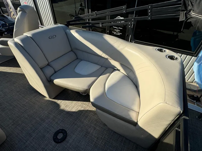 Slide: The Image of 2018 Harris Solstice 240 boat interior with beige seating and cup holders. - 22
