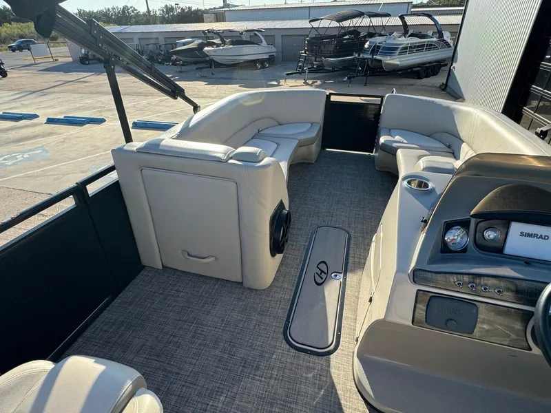 Slide: The Image of Interior of a 2018 Harris Solstice 240 pontoon boat with beige seating and dashboard. - 25