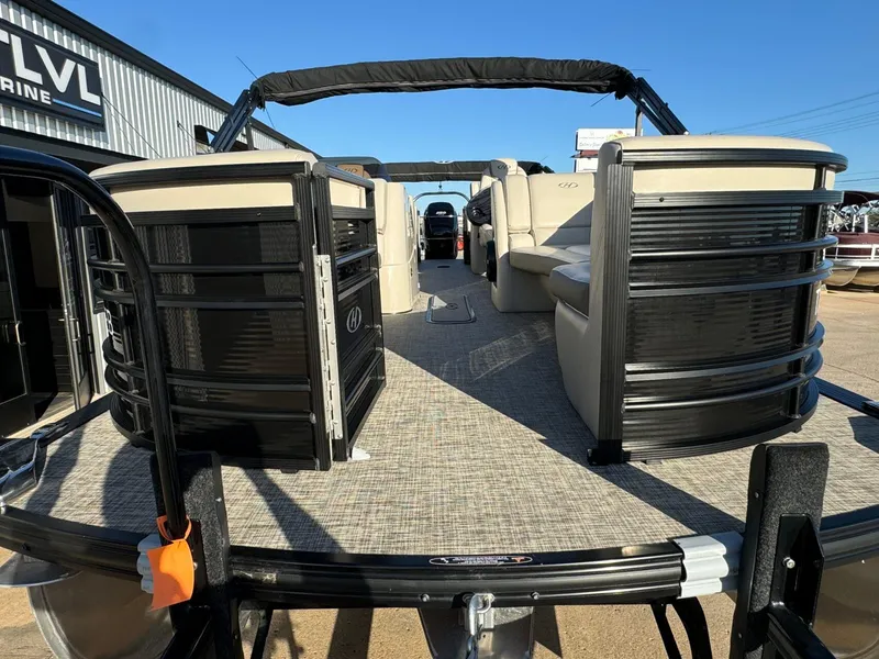 Slide: The Image of 2018 Harris Solstice 240 pontoon boat with beige seating, displayed at a marine dealership. - 8