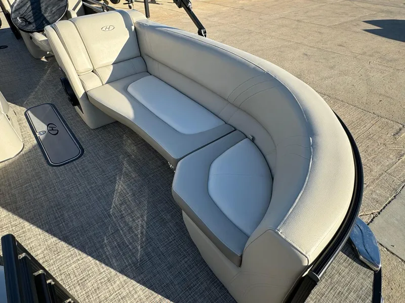 Slide: The Image of 2018 Harris Solstice 240 boat interior with beige seating and carpeted floor. - 9
