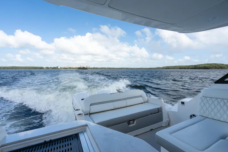 Slide: The Image of 2022 Regal 36 XO yacht cruising on open water, featuring luxurious seating and scenic views. - 13