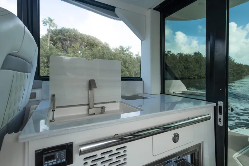 Slide: The Image of Modern kitchen area on 2022 Regal 36 XO yacht with sleek design and scenic view. - 15