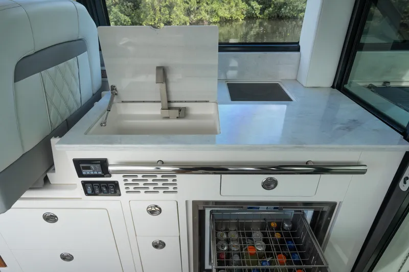 Slide: The Image of 2022 Regal 36 XO yacht kitchen with sink, countertop, and open fridge drawer. - 16