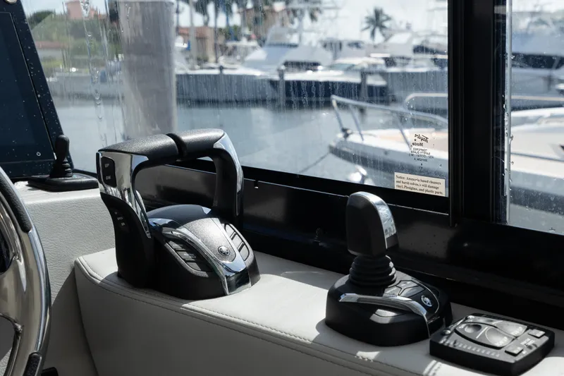 Slide: The Image of Regal 36 XO 2022 boat controls with marina view through window. - 22