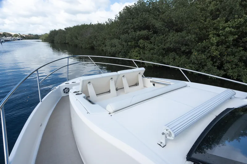 Slide: The Image of 2022 Regal 36 XO boat with sun deck on a serene waterway. - 29