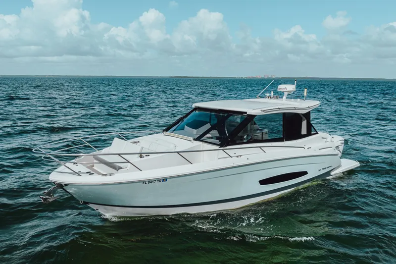 Slide: The Image of 2022 Regal 36 XO boat cruising on open water under a clear sky. - 5