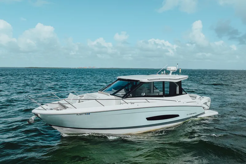 Slide: The Image of 2022 Regal 36 XO boat cruising on open water under a clear sky. - 6