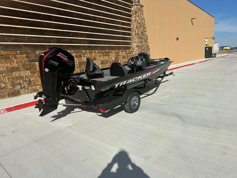 Slide: The Image of 2025 Tracker Pro Team 190 boat on trailer, black with red accents, parked outdoors. - 7
