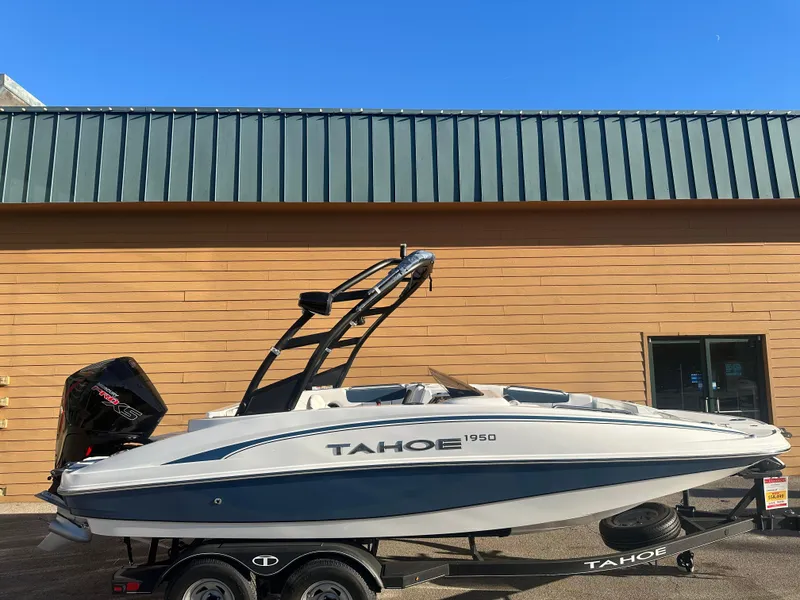 The Image of 2024 Tahoe 1950 boat on trailer, parked outside a building. - 0
