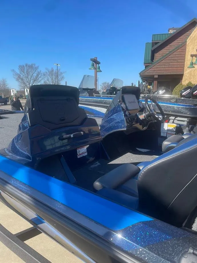 Slide: The Image of 2025 Nitro Z18 boat interior with dual seats and control panel, parked outdoors. - 2