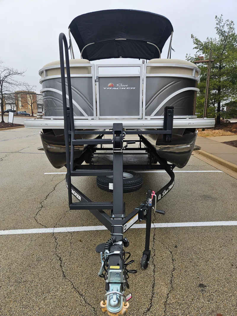 Slide: The Image of 2025 Sun Tracker Party Barge 22 DLX pontoon boat on trailer in parking lot. - 4