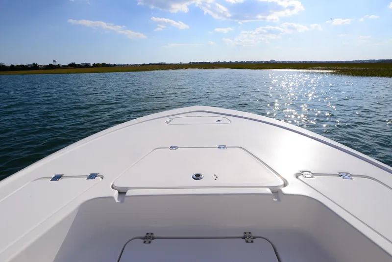 Slide: The Image of 2022 Tidewater 2110 Bay Max boat on serene water under blue sky. - 11
