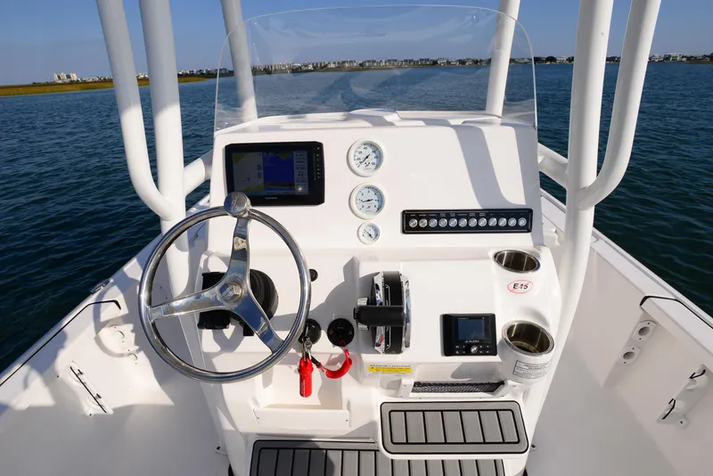 Slide: The Image of 2022 Tidewater 2110 Bay Max boat console with steering wheel and controls on water. - 19