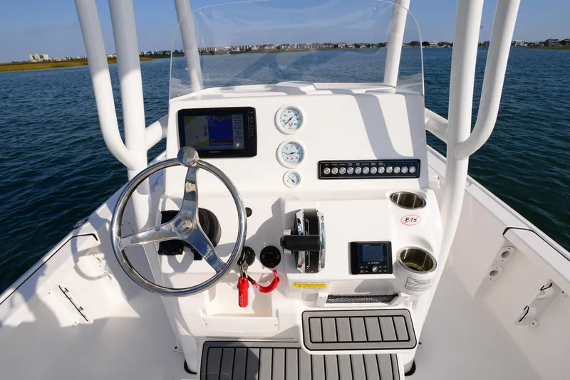 Slide: The Image of 2022 Tidewater 2110 Bay Max boat console with steering wheel and controls on open water. - 20