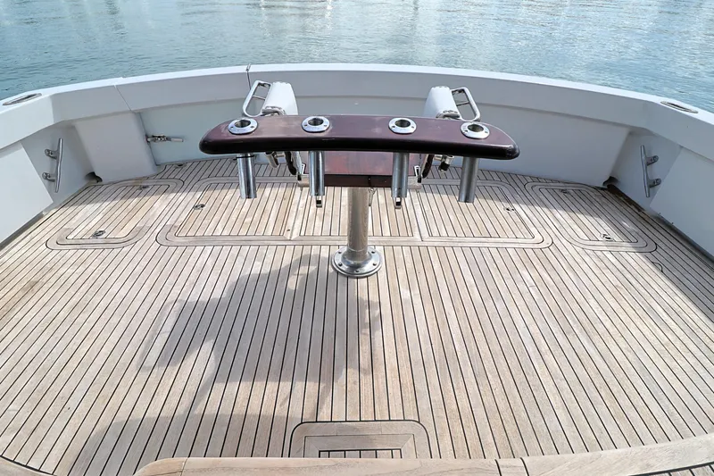 Slide: The Image of 2004 Hatteras 54 Convertible yacht deck with wooden flooring and fishing rod holders. - 15