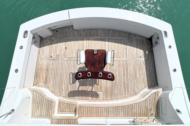 Slide: The Image of 2004 Hatteras 54 Convertible yacht deck with fishing chair, teak flooring, and ocean view. - 16