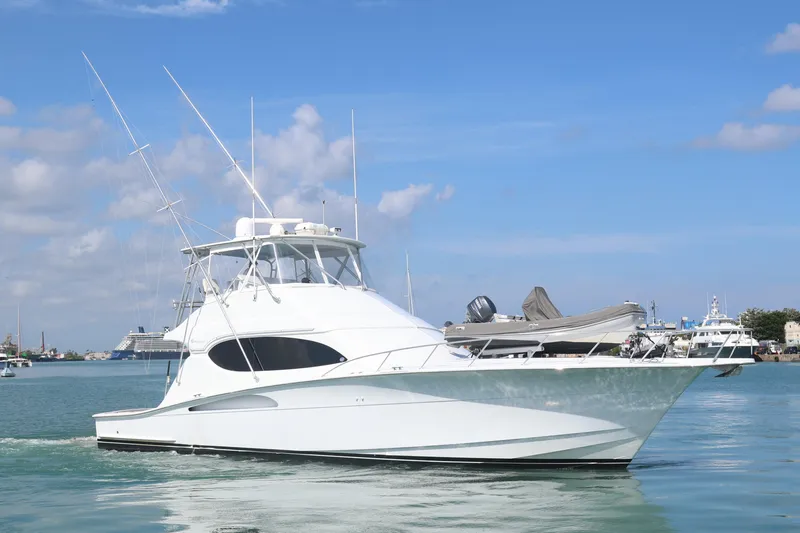 Slide: The Image of 2004 Hatteras 54 Convertible yacht on calm water under blue sky. - 2