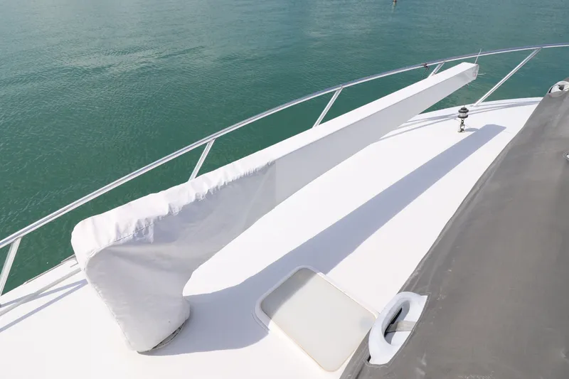 Slide: The Image of 2004 Hatteras 54 Convertible yacht deck with covered equipment, railing, and ocean view. - 20