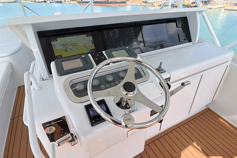 Slide: The Image of 2004 Hatteras 54 Convertible yacht helm with navigation equipment and wooden deck. - 21