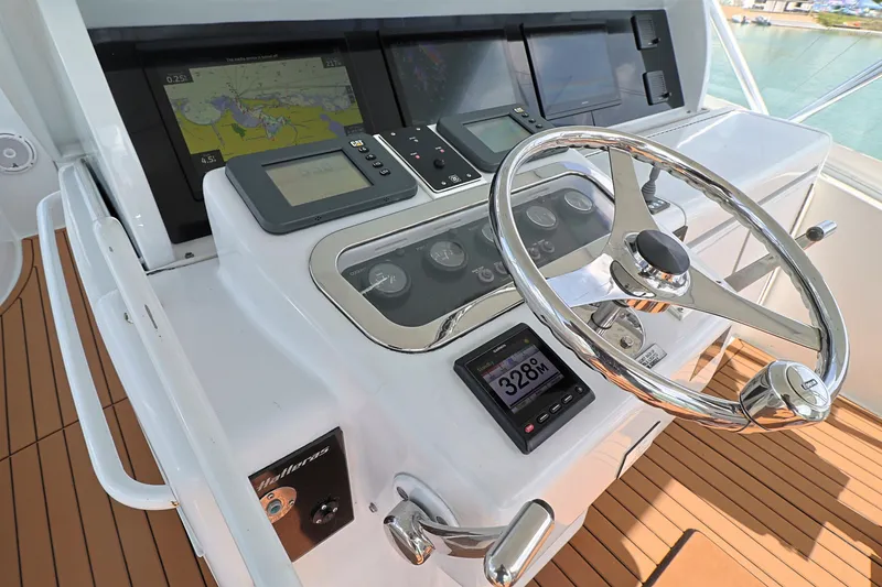 Slide: The Image of 2004 Hatteras 54 Convertible helm with navigation displays and steering wheel. - 23