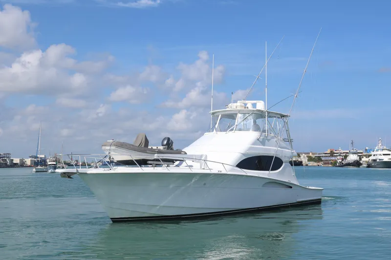 Slide: The Image of 2004 Hatteras 54 Convertible yacht on calm water under blue sky. - 3