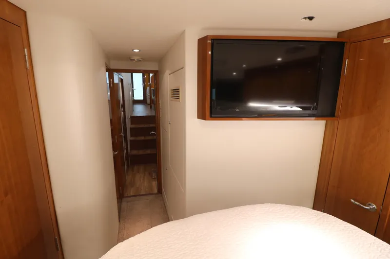 Slide: The Image of 2004 Hatteras 54 Convertible interior hallway with wall-mounted TV and wooden accents. - 44