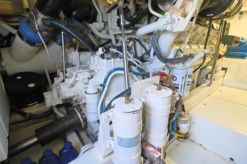 Slide: The Image of Engine room of a 2004 Hatteras 54 Convertible yacht, showcasing mechanical components and filters. - 49