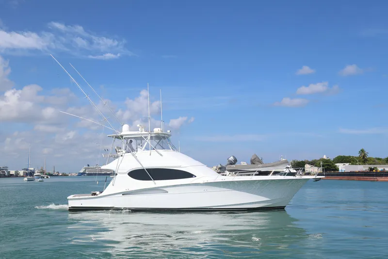 Slide: The Image of 2004 Hatteras 54 Convertible yacht cruising on calm waters under a clear blue sky. - 5