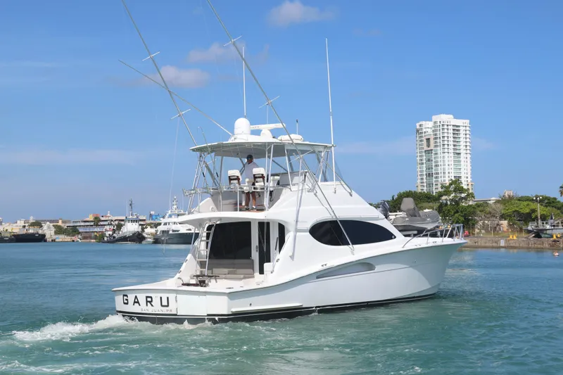 Slide: The Image of 2004 Hatteras 54 Convertible yacht cruising in a harbor with clear skies. - 6