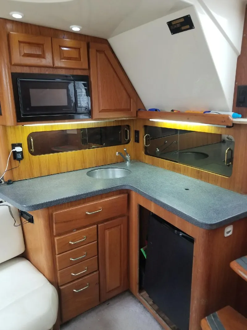 Slide: The Image of 2002 Luhrs Express boat interior kitchen with wood cabinets and modern appliances. - 13