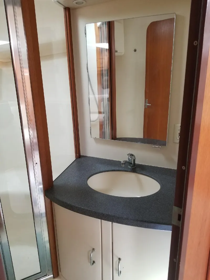 Slide: The Image of 2002 Luhrs Express bathroom with sink, mirror, and wooden accents. - 15
