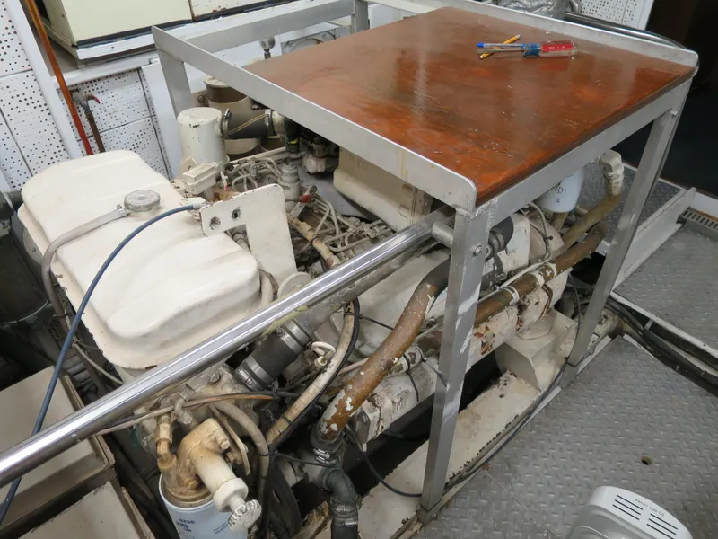 Slide: The Image of Engine room of a 1988 DeFever 53POC yacht, featuring mechanical components and tools. - 20