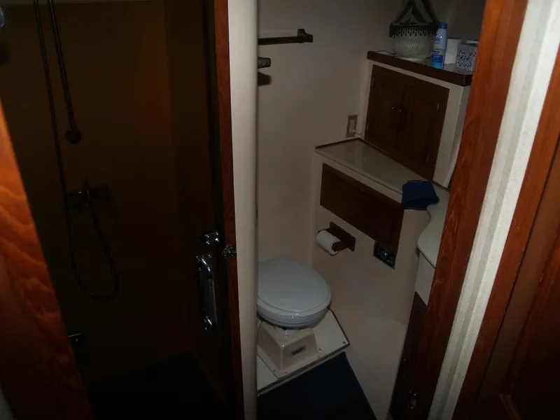 Slide: The Image of 1988 DeFever 53POC yacht bathroom with shower, toilet, and wooden cabinetry. - 22