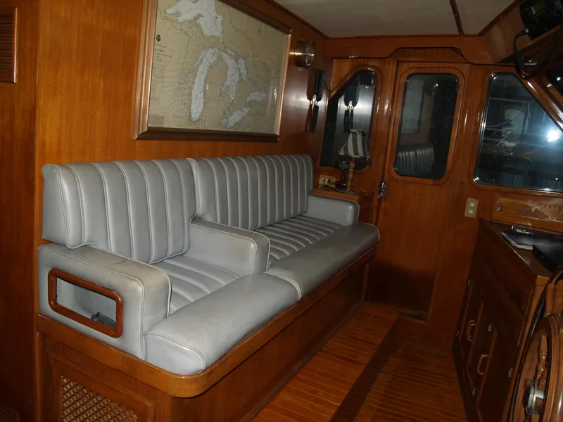 Slide: The Image of 1988 DeFever 53POC yacht interior with gray seating and wooden accents. - 25