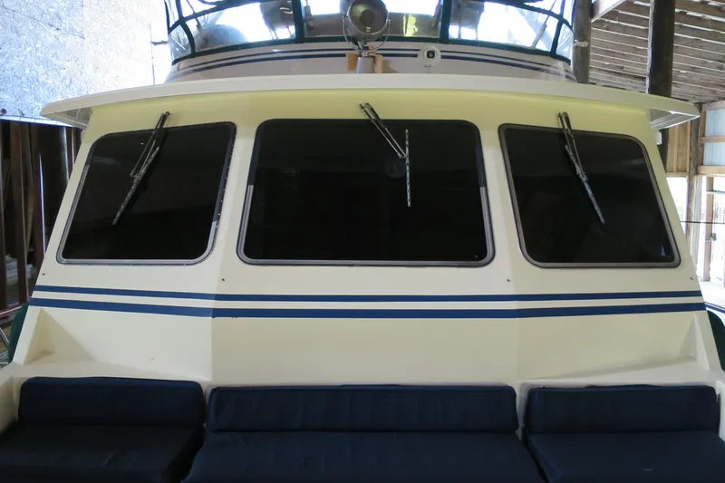 Slide: The Image of 1988 DeFever 53POC yacht with large windows and blue-striped exterior. - 4