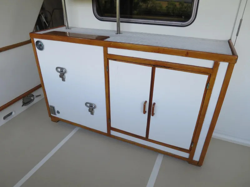 Slide: The Image of 1988 DeFever 53POC yacht interior with wooden-trimmed white storage cabinet. - 6