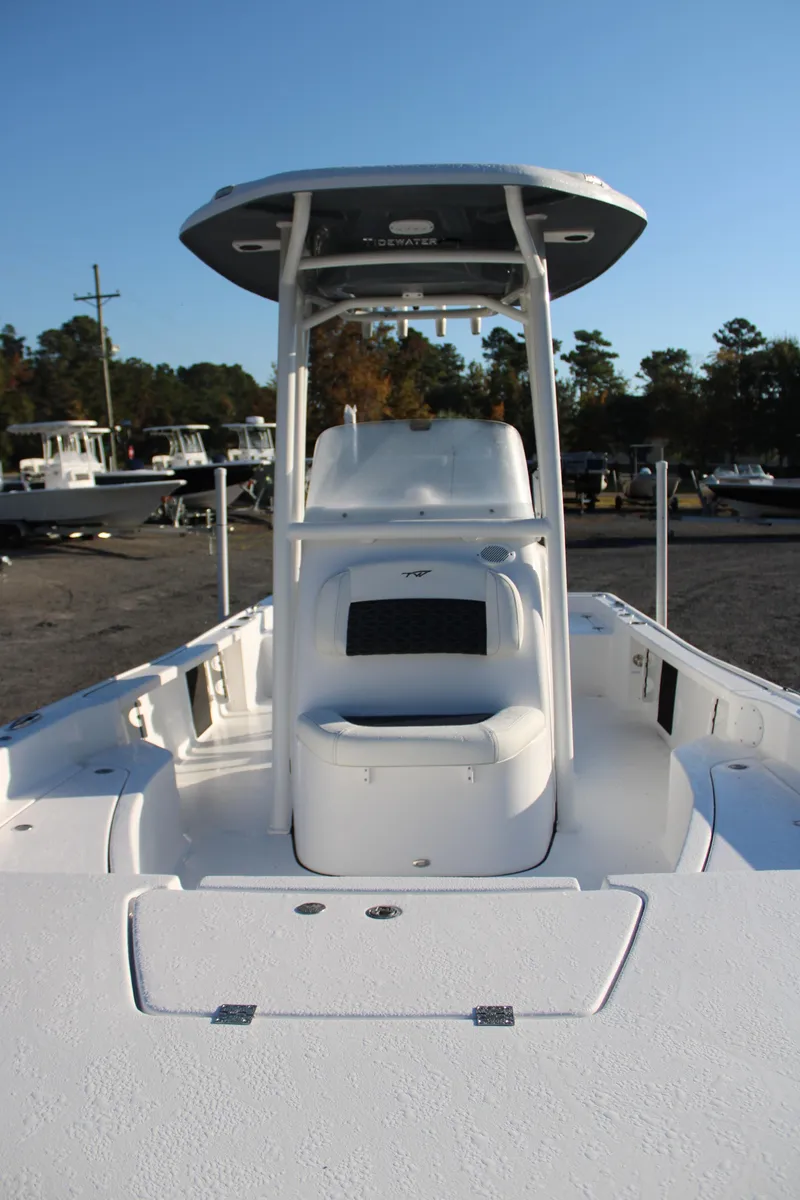 Slide: The Image of 2025 Tidewater 2210 Carolina Bay boat with T-top and seating, docked outdoors. - 17
