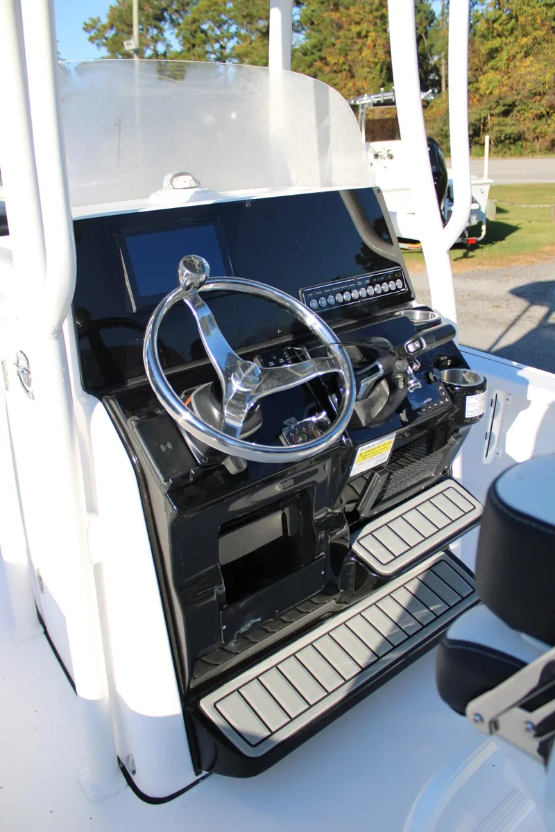 Slide: The Image of 2025 Tidewater 2210 Carolina Bay boat console with steering wheel and controls. - 19