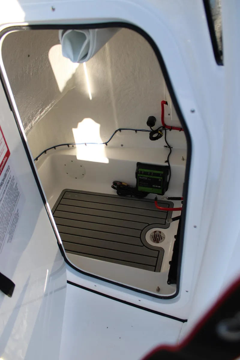 Slide: The Image of 2025 Tidewater 2210 Carolina Bay boat storage compartment with electrical components. - 22