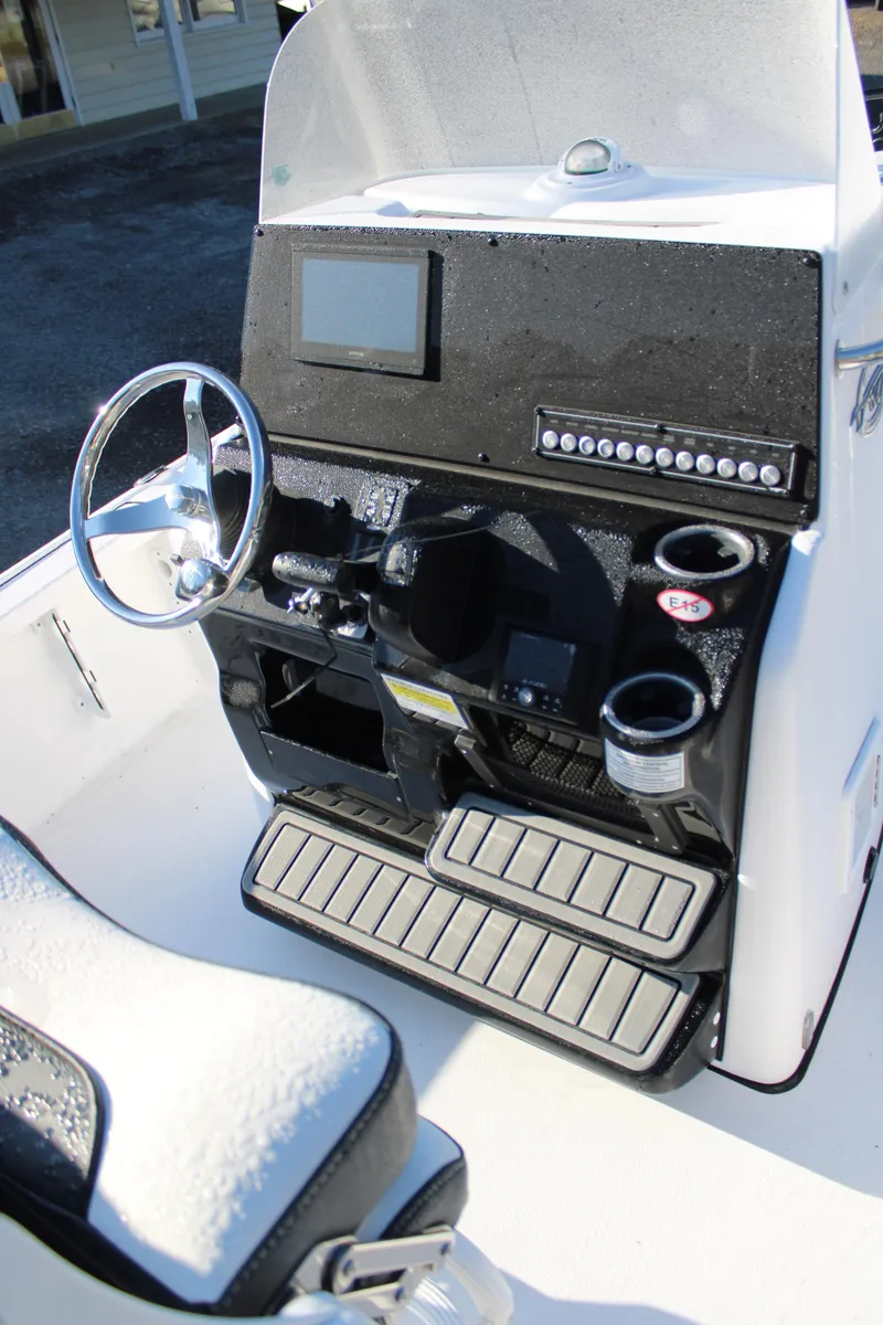 Slide: The Image of 2025 Tidewater 2210 Carolina Bay boat console with steering wheel and electronic controls. - 27
