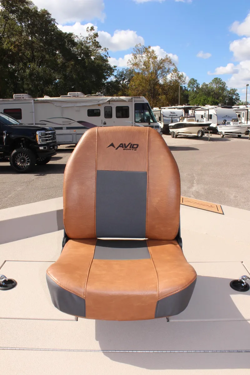 Slide: The Image of Avid 18 Rogue CC 2025 boat seat, brown and gray, outdoor setting. - 17