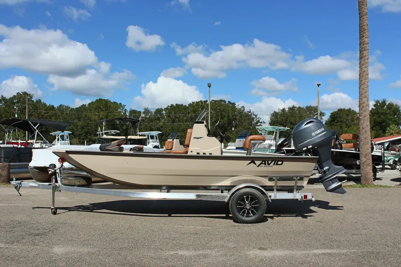 Slide: The Image of 2025 Avid 18 Rogue CC boat on trailer, parked outdoors under blue sky. - 2